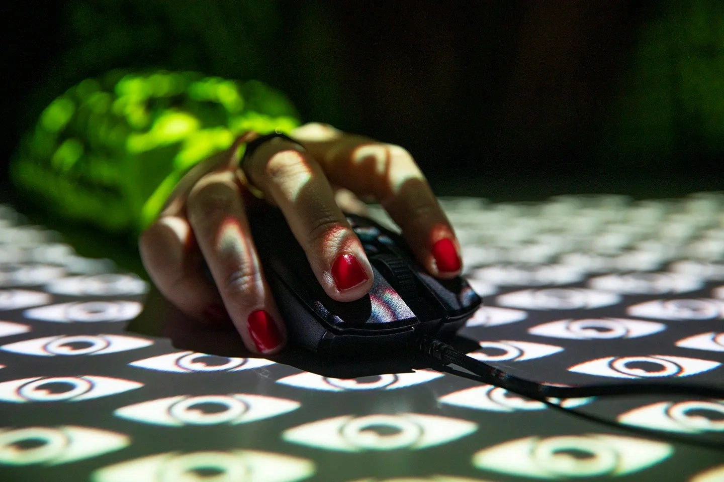 Mão segurando um mouse com olhos estilizados projetados sobre a imagem